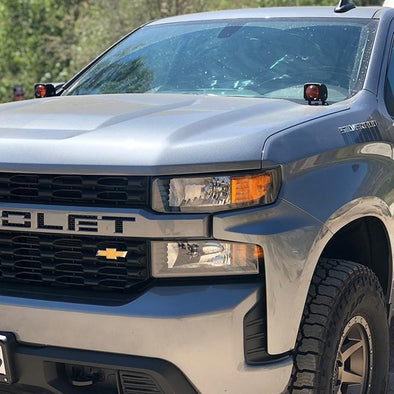 An image of APS ultra beam amber light pods mounted on the hood of a 2019 Chevy Silverado